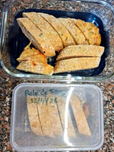 A whole, golden homemade chicken roll fresh from the oven, resting on parchment paper on the baking sheet, with a crispy breadcrumb crust