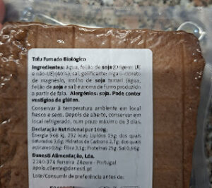 Open package of organic smoked tofu with Portuguese label showing ingredients, allergens and nutritional table.