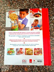 Contracapa do livro "A Mamã & Eu Na Cozinha" com fotografias de crianças a cozinhar, texto descritivo em português e quatro miniaturas de receitas, sobre bancada de granito.