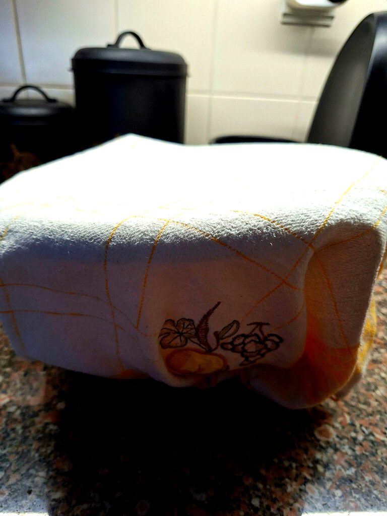 White bowl with thick, smooth sweet dough on a granite countertop
