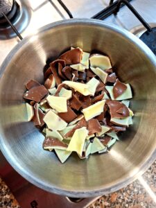 Metal bowl with pieces of dark and white chocolate ready to be melted on the stovetop.