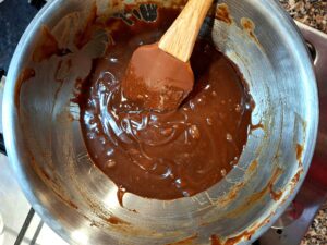 Bowl with melted chocolate and a silicone spatula, showing a smooth, glossy texture.
