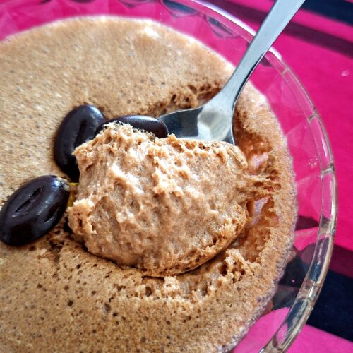 Spoon lifting a portion of chocolate mousse, showing its light, fluffy texture.