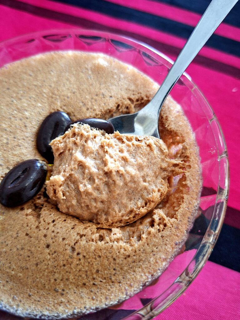 Spoon lifting a portion of chocolate mousse, showing its light, fluffy texture.