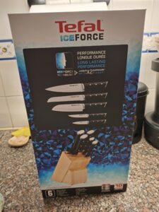 Box of the Tefal Ice Force 6‑piece knife set with wooden block, showing the five knives and Ice Force technology, with a 10‑year guarantee, placed on a kitchen countertop.